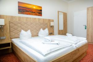 a bedroom with a large bed with white sheets at Waldhotel Friedrichroda in Friedrichroda