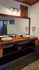 Isletas de Granada的住宿－Zopango Orchids Island，一间带两个盥洗盆和大镜子的浴室