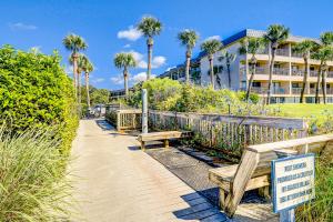 a walkway with benches in front of a building at Sea Side Villas 244 in Hilton Head Island