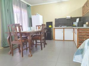 een keuken en eetkamer met een tafel en stoelen bij Garden cottages near Savannah Mall in Polokwane