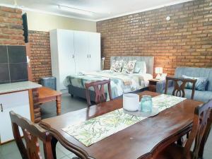 a living room with a table and a bed at Garden cottages near Savannah Mall in Polokwane