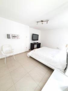 1 dormitorio blanco con 1 cama y 1 silla en Ubicadisimo Departamento en 3BED Polanco, en Ciudad de México