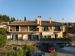 a house with two cars parked in front of it at Xenia's Apartments in Alepou in Corfu