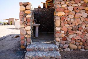 a stone wall with a doorway leading into a building at Farm’s guest room in Nuweiba