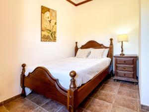 1 dormitorio con cama de madera y mesita de noche en Quinta do Cutato - Beatriz Guest House - A2 en Santo Estêvão