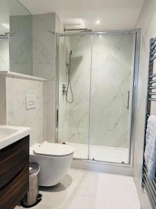 een witte badkamer met douche en toilet bij Borough Central London in Londen