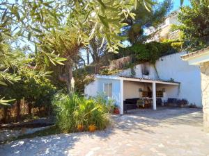 una casa blanca con árboles y un patio en Villa Max en Lloret de Mar