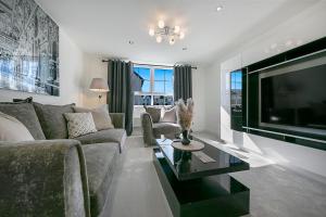 a living room with a couch and a flat screen tv at Fern Place Villa - Grampian Lettings Ltd 