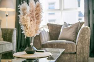 eine Vase getrockneten Grass auf einem Tisch im Wohnzimmer in der Unterkunft Fern Place Villa - Grampian Lettings Ltd 