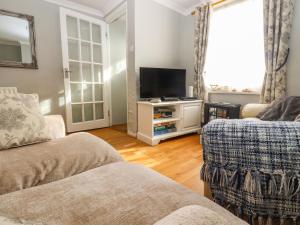 a living room with a couch and a tv at Sea Beach Cottage in Eastbourne