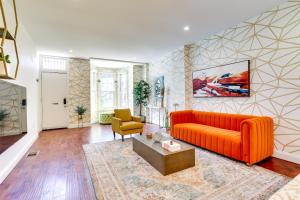 a living room with an orange couch and a table at Chic Philadelphia Townhome in University City! in Philadelphia