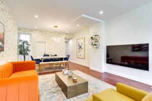 Chic Philadelphia Townhome in University City! في فيلادلفيا: غرفة معيشة مع أريكة برتقالية وطاولة