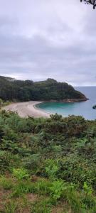 ein Strand inmitten eines Gewässers in der Unterkunft Casa da Oliveira in Cariño