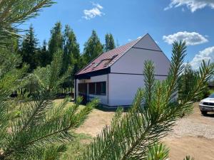 una casa blanca con techo de gambrel en Mazurskie Energie dom ekologiczny całoroczny, en Stare Juchy