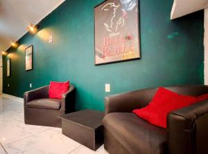 a living room with two couches and a green wall at Cozy Apartment 10 min from downtown in San Luis Potosí