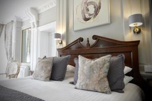 a bedroom with a bed with a wooden headboard and pillows at Cley Hall in Spalding