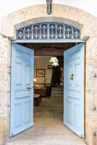 una entrada a una casa con puertas azules en El Jardín del Laurel, en Candelario