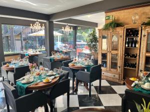 restauracja ze stołami i krzesłami oraz oknem w obiekcie Pousada Dona Bendita w mieście Monte Verde