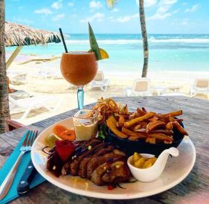 a plate of food on a table next to the beach at Studio Climatisé avec Réservoir d'eau in Saint-François