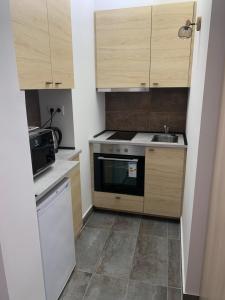 a small kitchen with a stove and a sink at Infinity Apartman in Esztergom