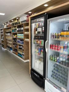 an open refrigerator in a store with drinks at Pousada do Sol in Penedo