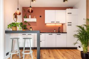 a kitchen with white cabinets and bar stools at Boutique Studio Amsterdam near RAI and De Pijp in Amsterdam