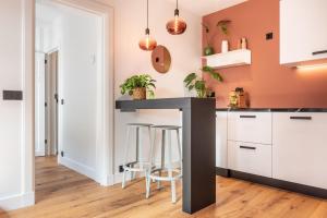 a kitchen with a black counter and stools at Boutique Studio Amsterdam near RAI and De Pijp in Amsterdam