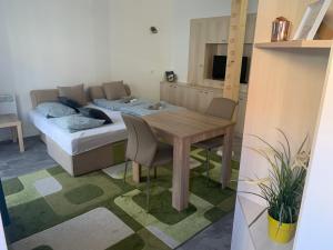 a room with a table and a bed and a table and chairs at Infinity Apartman in Esztergom