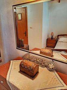 a mirror on a bed with a cake on a table at Panthea Cottage in Stavroupoli