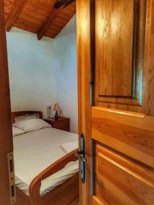 a bedroom with a bed and a wooden door at Panthea Cottage in Stavroupoli