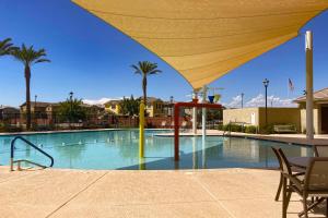 a large swimming pool with a large yellow umbrella at Desert Diamond in Gilbert