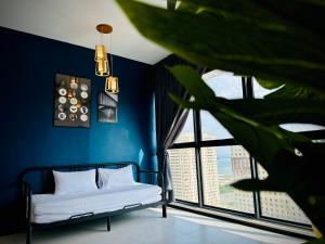 een blauwe kamer met een bed en een groot raam bij Urban Suite Cozy Family Homestay at Georgetown by Heng Penang Homestay in Jelutong