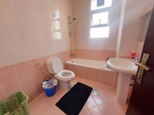 een badkamer met een toilet, een wastafel en een bad bij Nice studio for stay .. in Al Ain
