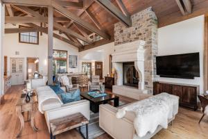 a living room with a stone fireplace and a tv at Chateau at Elk Spring in Edwards