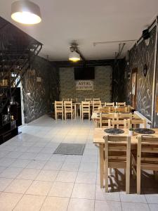 a dining room with wooden tables and wooden chairs at Antal Guesthouse in Ghimeş-Făget
