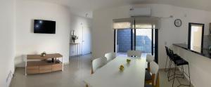 - un salon blanc avec une table et des chaises blanches dans l'établissement La Palmerita, à Villa Carlos Paz