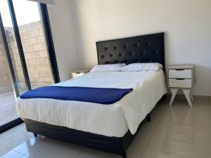 a bedroom with a large bed with a blue blanket at La Palmerita in Villa Carlos Paz