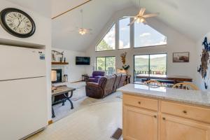 uma cozinha e sala de estar com um relógio na parede em Murphy Cabin with Deck and Sweeping Mountain Views! em Murphy