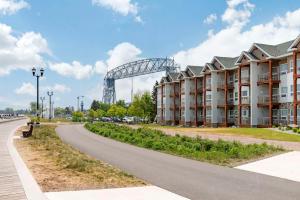 a road next to a building with a bridge in the background at Lift Bridge Lodge, Ascend Hotel Collection in Duluth