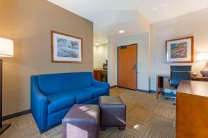 a living room with a blue couch and a desk at Lift Bridge Lodge, Ascend Hotel Collection in Duluth