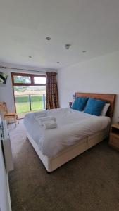 a large bed in a bedroom with a window at Rutland Point apartment Serviced Accommodation Keystones Property Services in Morcott