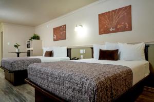 a hotel room with two beds in a room at Family Garden Inn & Suites in Laredo