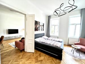 um quarto com uma cama, um sofá e uma cadeira em Iconic Suite_@O&R em Viena