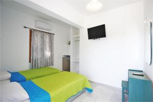 a bedroom with a bed and a flat screen tv at Nostos Plaka Beach in Plaka