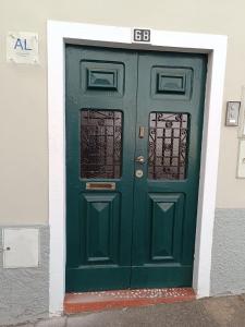uma porta verde com um sinal em Casa Camões em Bragança