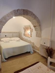 - une chambre avec un lit doté d'une arche en pierre dans l'établissement Luxury Trulli sabotino, à Alberobello