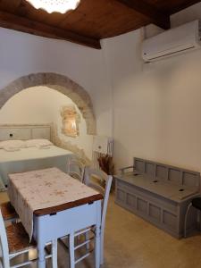 - une chambre avec un lit, une table et des chaises dans l'établissement Luxury Trulli sabotino, à Alberobello