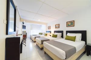 Hotel Virrey 76 في بارانكويلا: غرفة فندقية بسريرين ومكتب