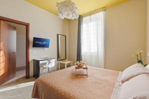 ローマにあるB&B L'Amacaのベッドルーム1室(ベッド1台、テーブル、デスク付)