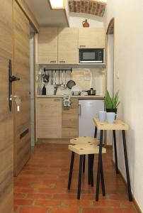 a small kitchen with two tables and a refrigerator at Podroom Apartments in Ljubljana